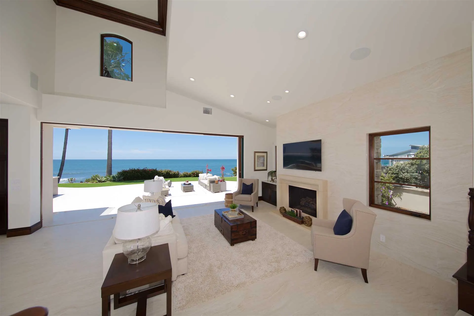 Renovated great room with a vaulted ceiling and a wall of glass opening onto a patio