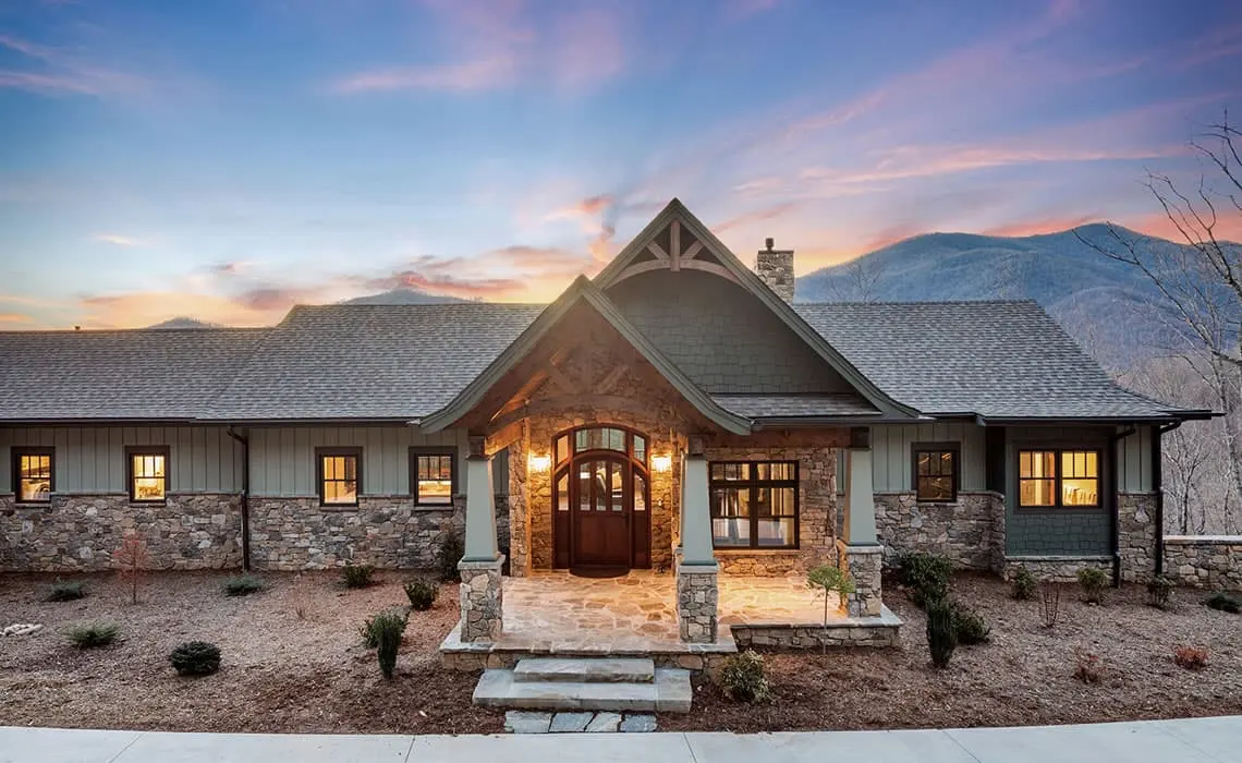 Custom home on a rural site with mountains behind it at sunset