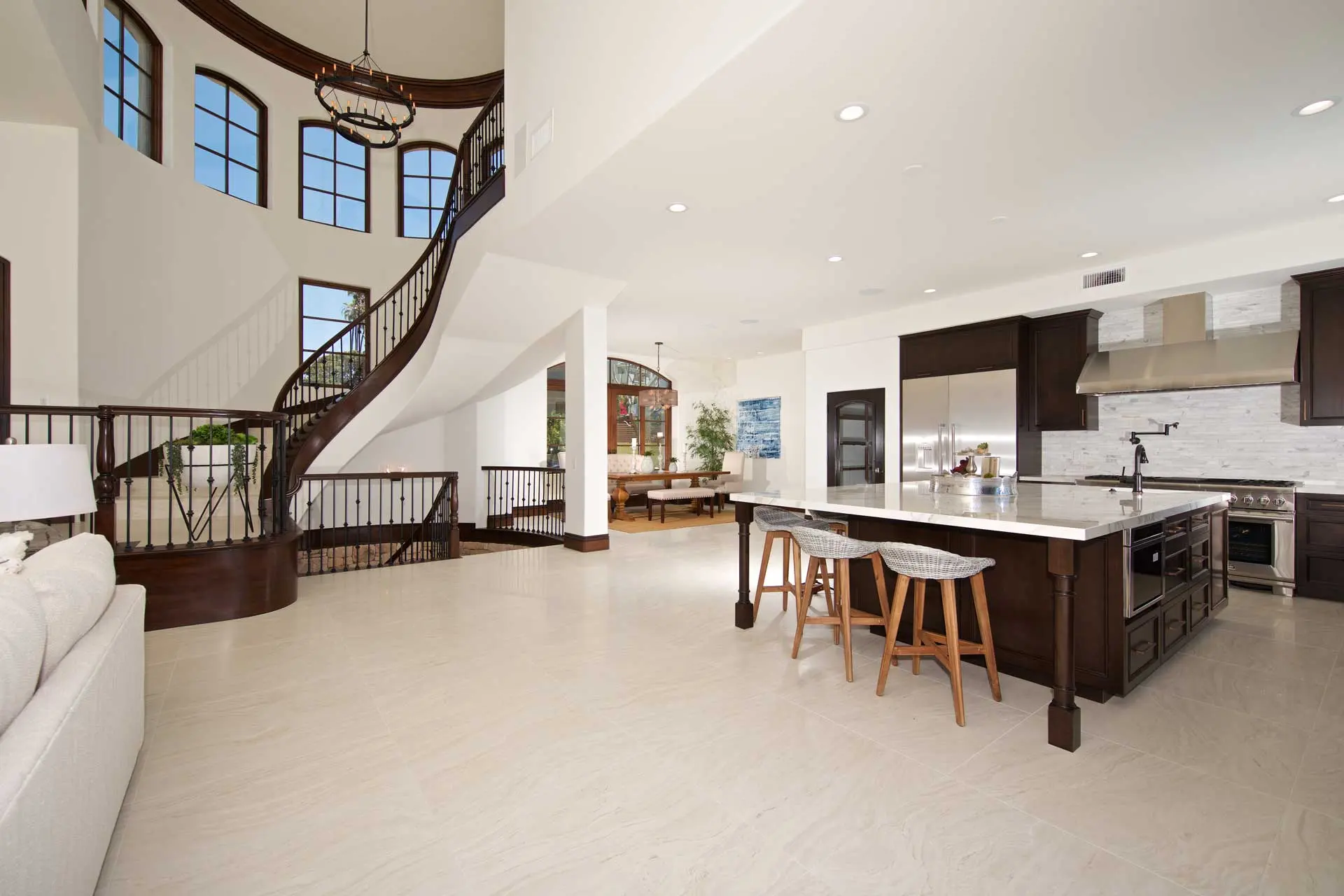 Open-concept kitchen and two-storey great room with a curved staircase after renovation